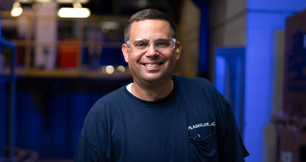 Smiling PLASKOLITE employee