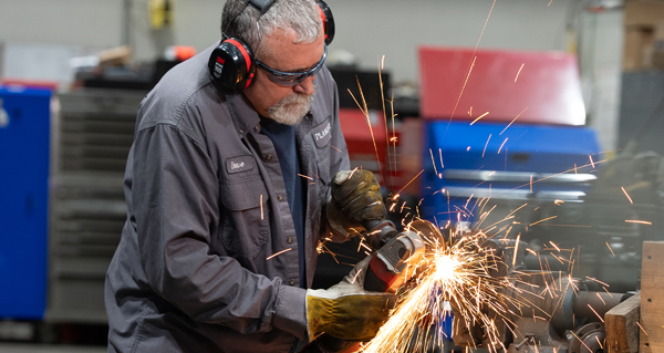 Technician grinding metal