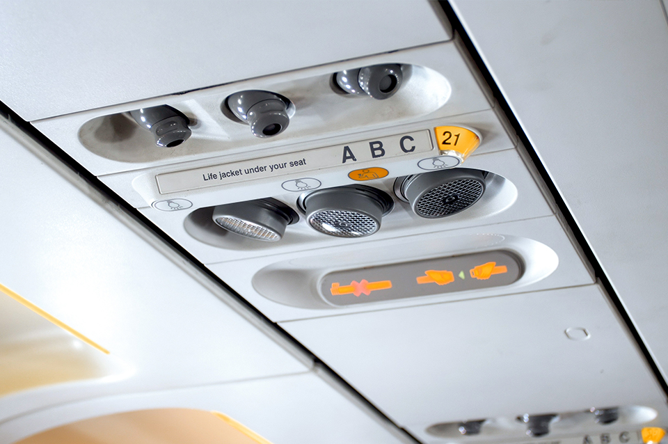 Overhead commercial vents and lighting in an airplane, featuring aircraft interior plastic.